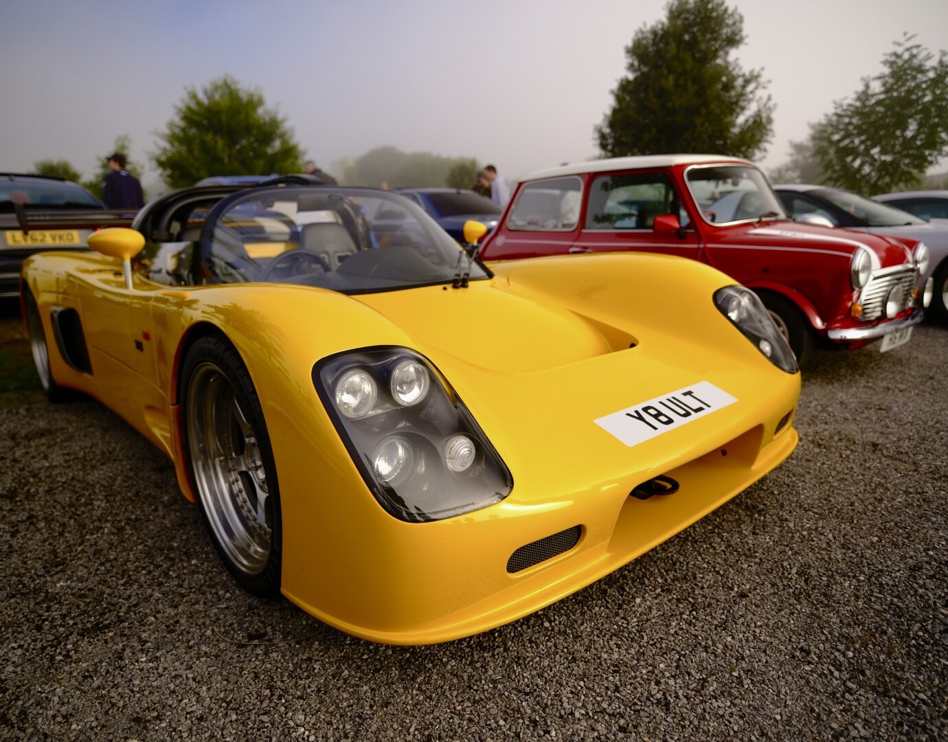 A yellow Ultima V8 at a car show, shot close on the Viltrox 13mm f/1.4.